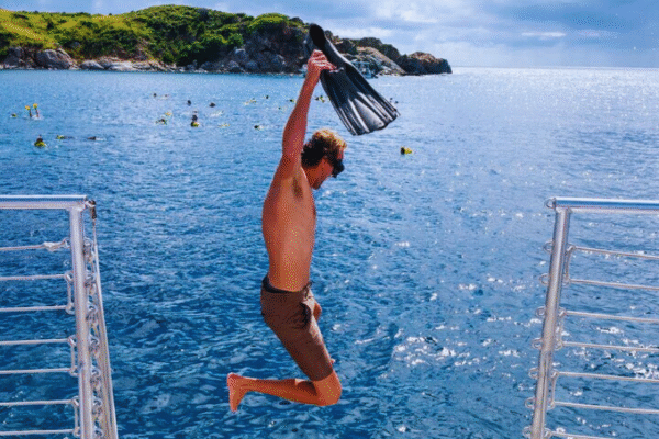 Chukka Private Catamaran Charter Man Jumping in Water