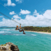 Chukka Ocean Double: ATV or Dune Buggy and Ocean Zipline Adventure Lady Ziplining Over Ocean