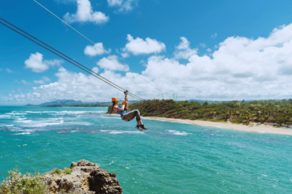 Chukka Ocean Double: ATV or Dune Buggy and Ocean Zipline Adventure Lady Ziplining Over Ocean